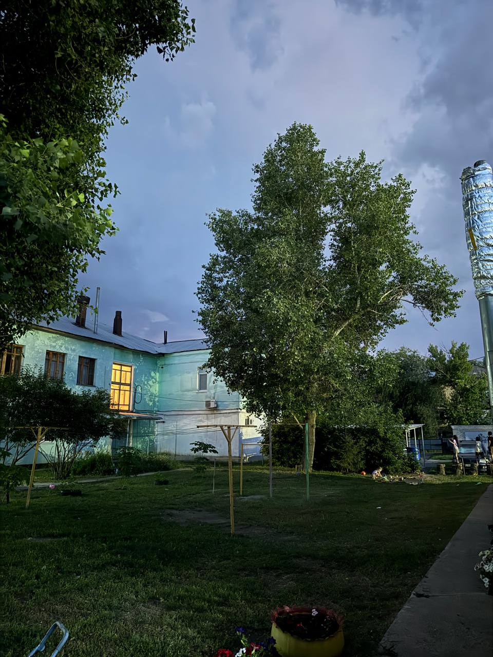 A courtyard under a dark thunderstorm sky